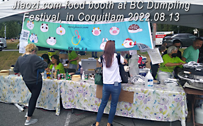 front view of 2022 Jiaozi booth, with cashiers , Nicole & Pearl, on left and 3 of volunteers on far right near the steamer equipment