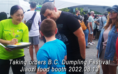 Mona Chan taking orders from people lining up at the Jiaozi food booth