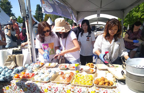 women volunteers filling buns order on side of Jiaozi vendor tent